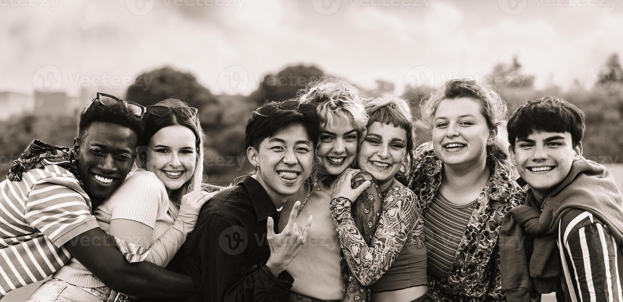 Young multi ethnic friends having fun together hanging out in the city - Friendship and diversity concept - Black and white editing photo