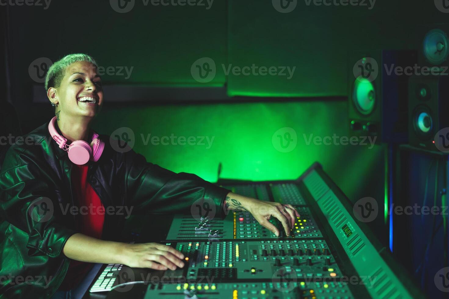 Young woman working in music recording studio - Female audio engineer mixing a sound in production house photo