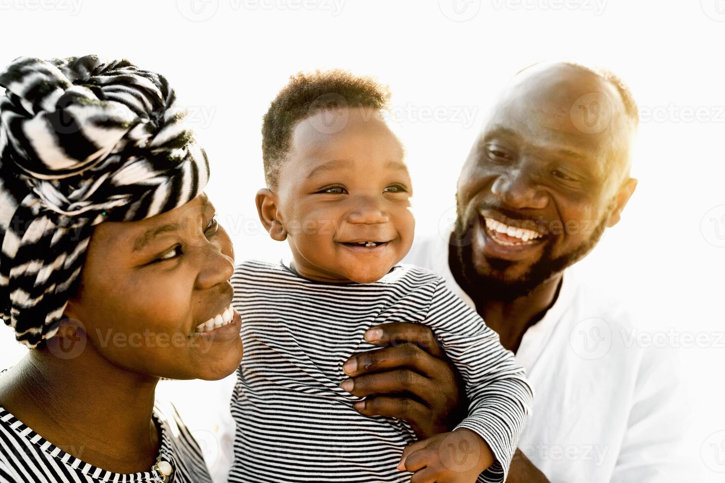 Happy African family having fun on the beach during summer holidays - Parents love concept photo