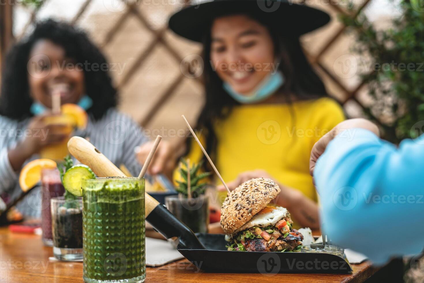 Multiracial friends having healthy lunch in coffee brunch bar during corona virus outbreak photo