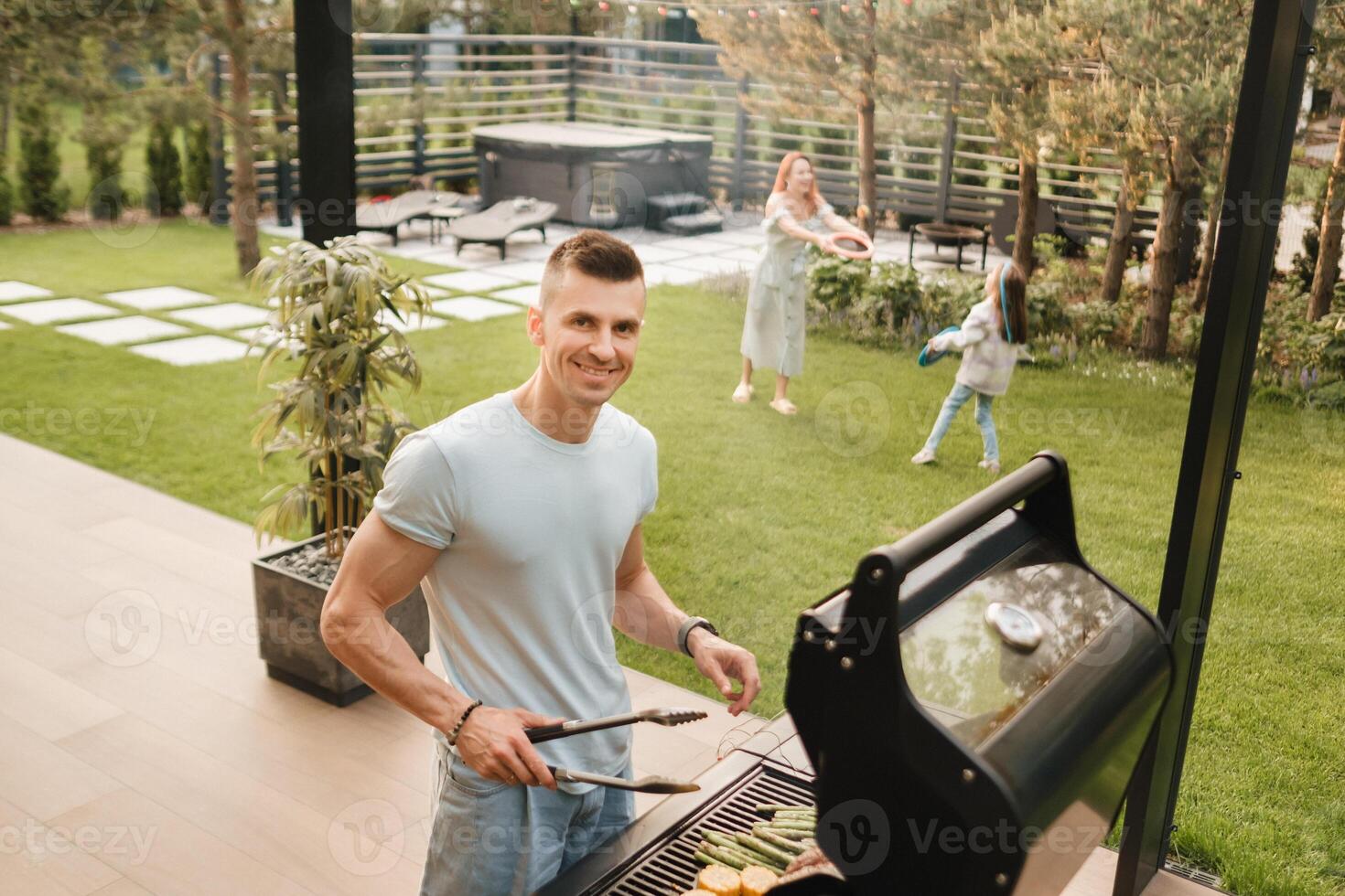 A man on the street is cooking a steak on the grill at a barbecue photo