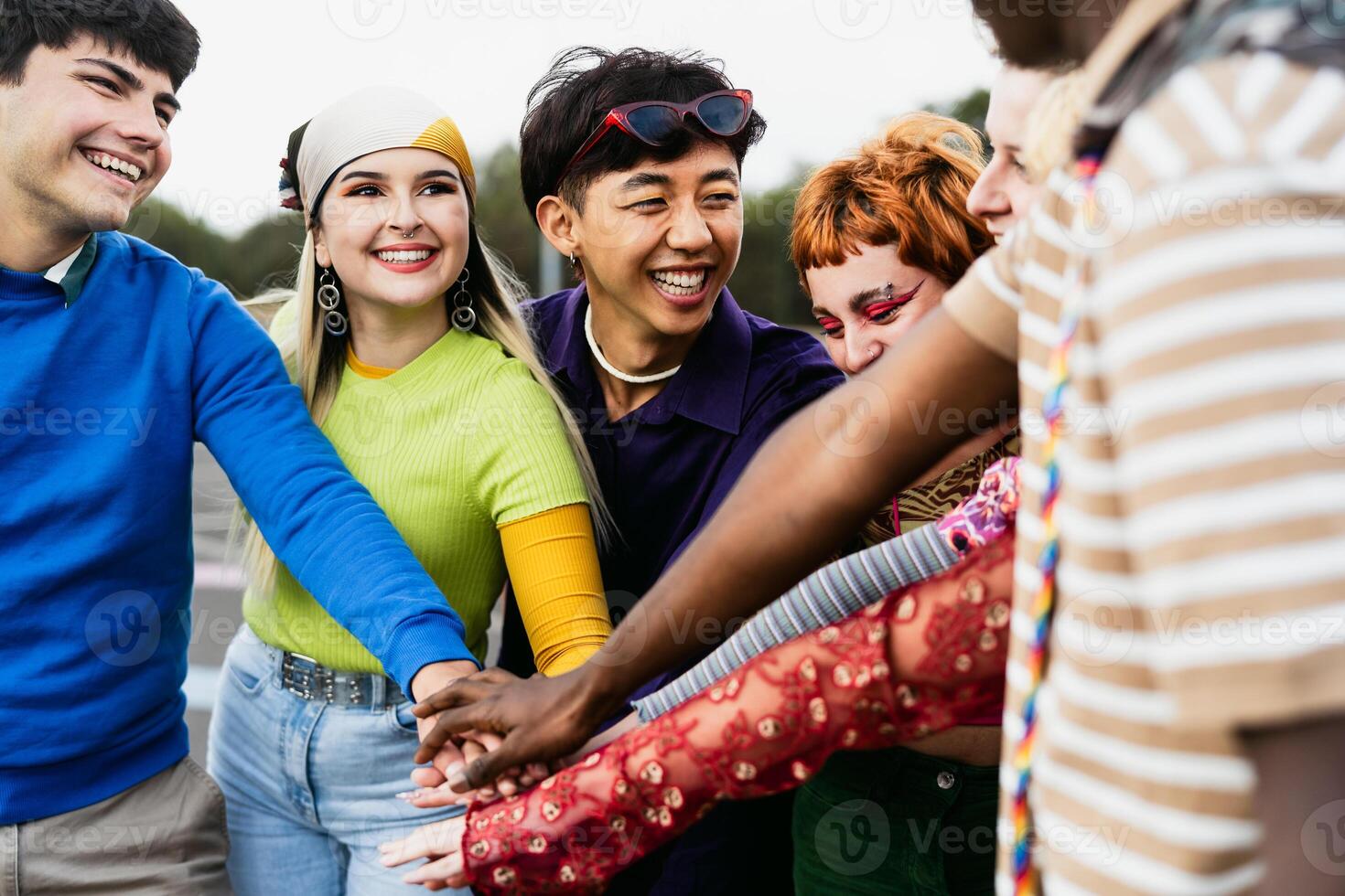 Happy young diverse friends having fun stacking hands together outdoor - Youth people millennial generation concept photo