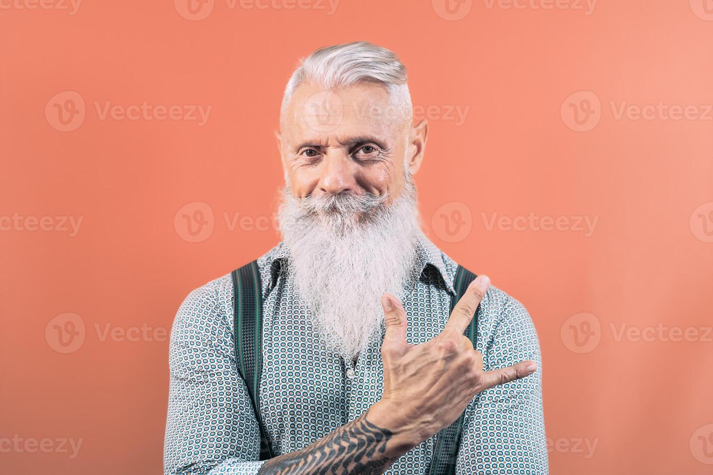 Senior man having fun posing in front camera - Happy mature male enjoying retired time - Elderly people lifestyle and hipster culture concept photo