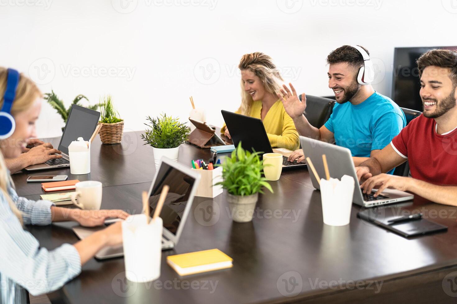 Young friends working together inside co-working creative space - Millennial people doing startup strategy in modern office - Youth co-workers generation and technology concept photo