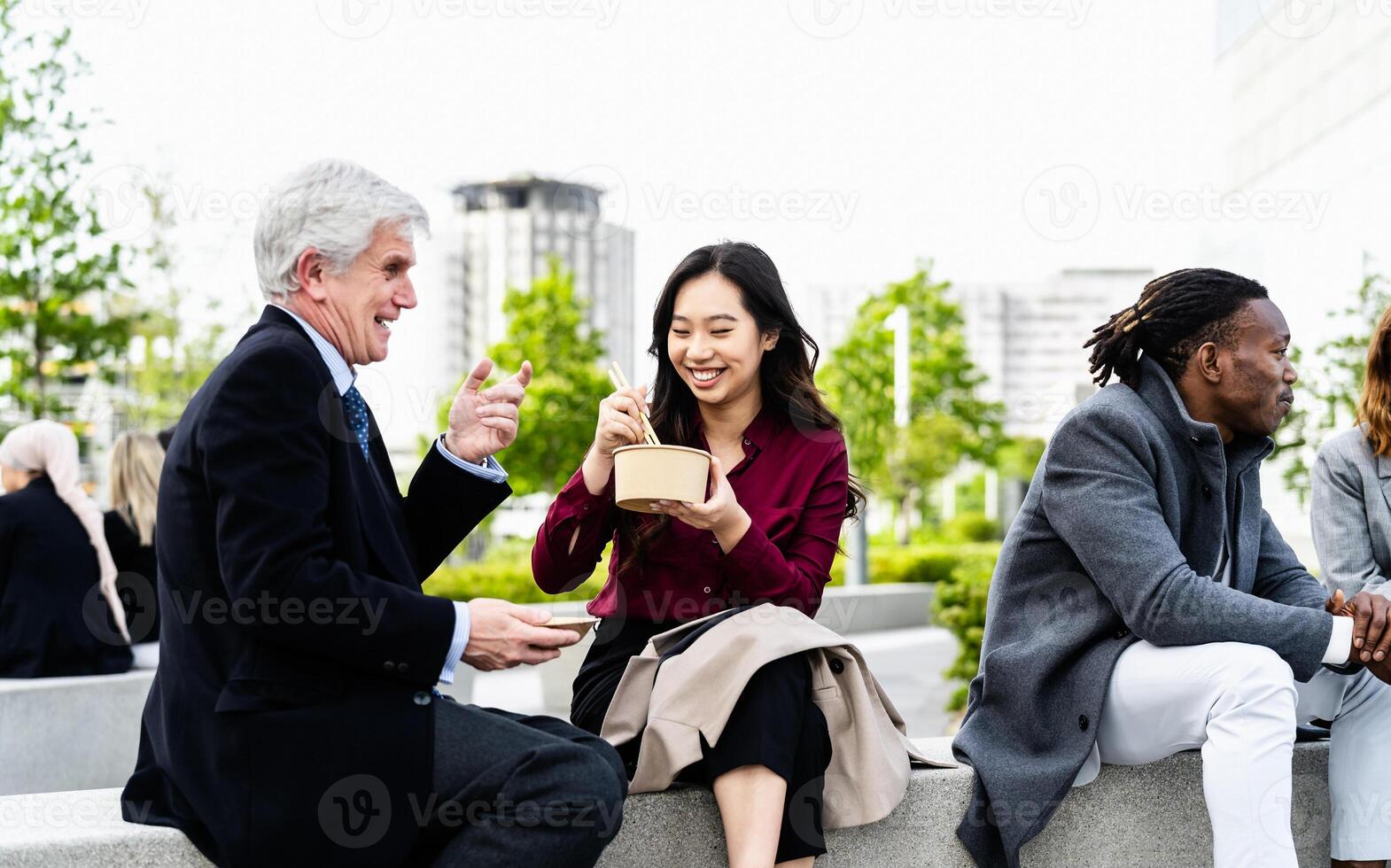 Happy multiracial business people having a lunch break outside office photo