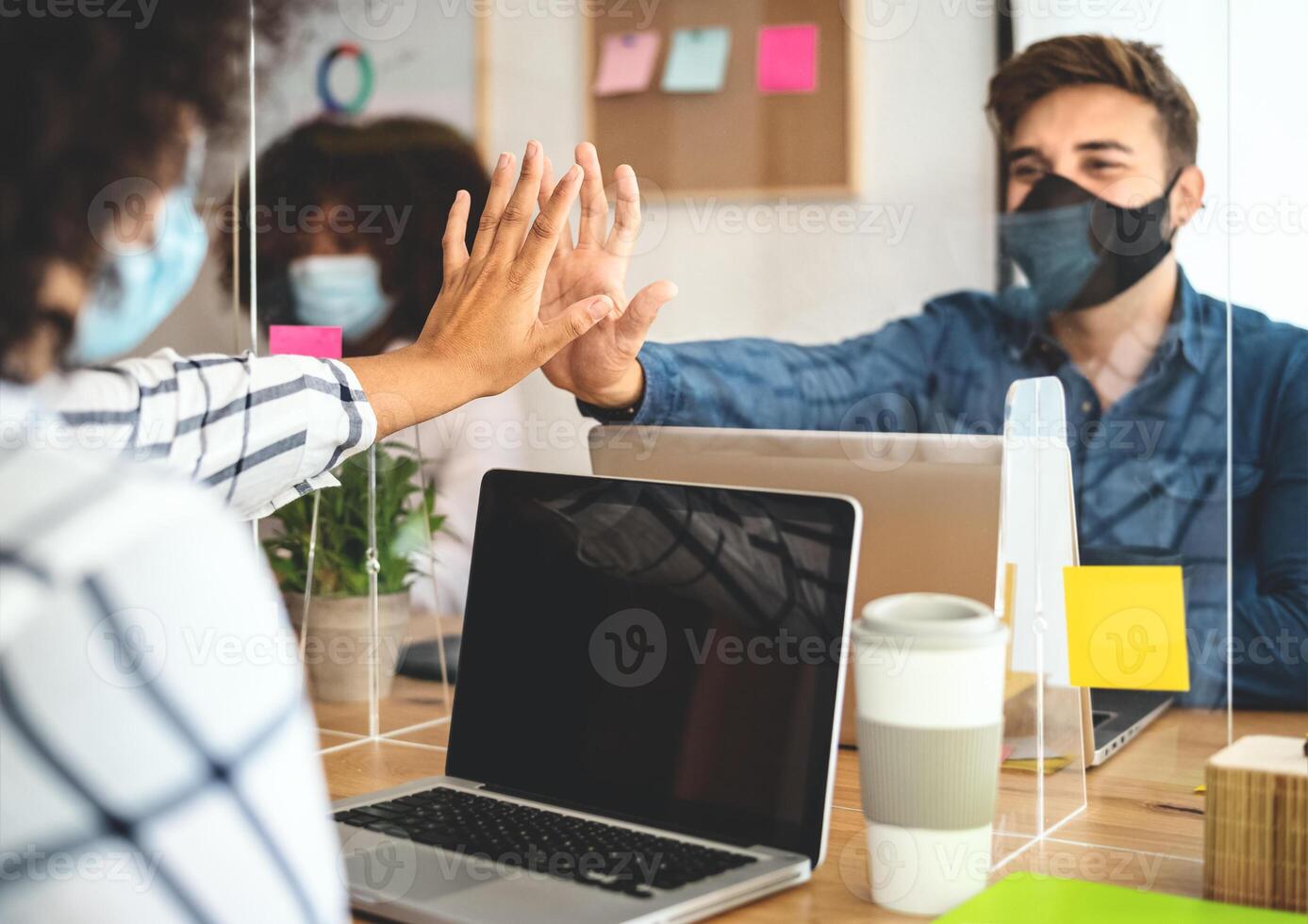 Young people in co-working creative space wearing surgical mask protection and keeping social distance to avoid corona virus spread - Health care and business technology concept photo
