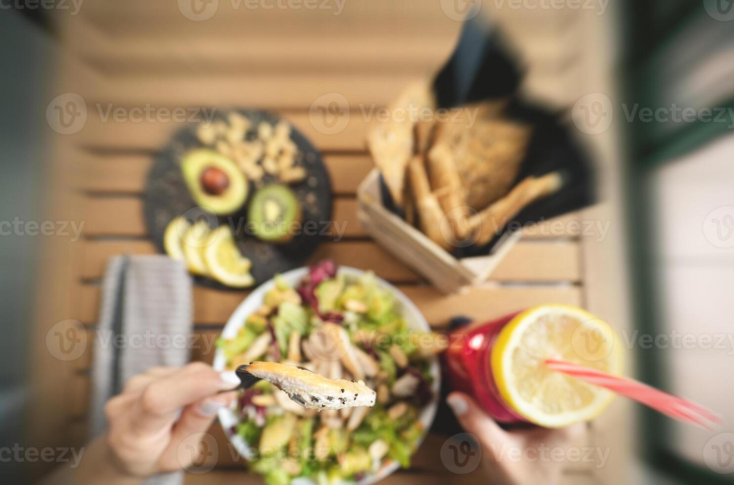 Top view female hands eating health vegetable salad with chicken breast avocado and kiwi drinking fresh smoothie fruit - Healthy nutrition food lifestyle people concept photo