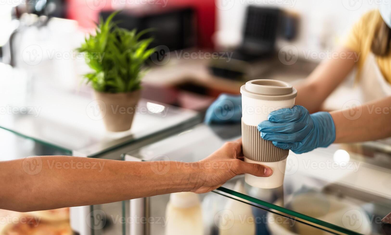 Bar owner working only with take away orders during corona virus outbreak - Young woman worker wearing face surgical mask giving coffee to customer - Healthcare and drinks concept photo