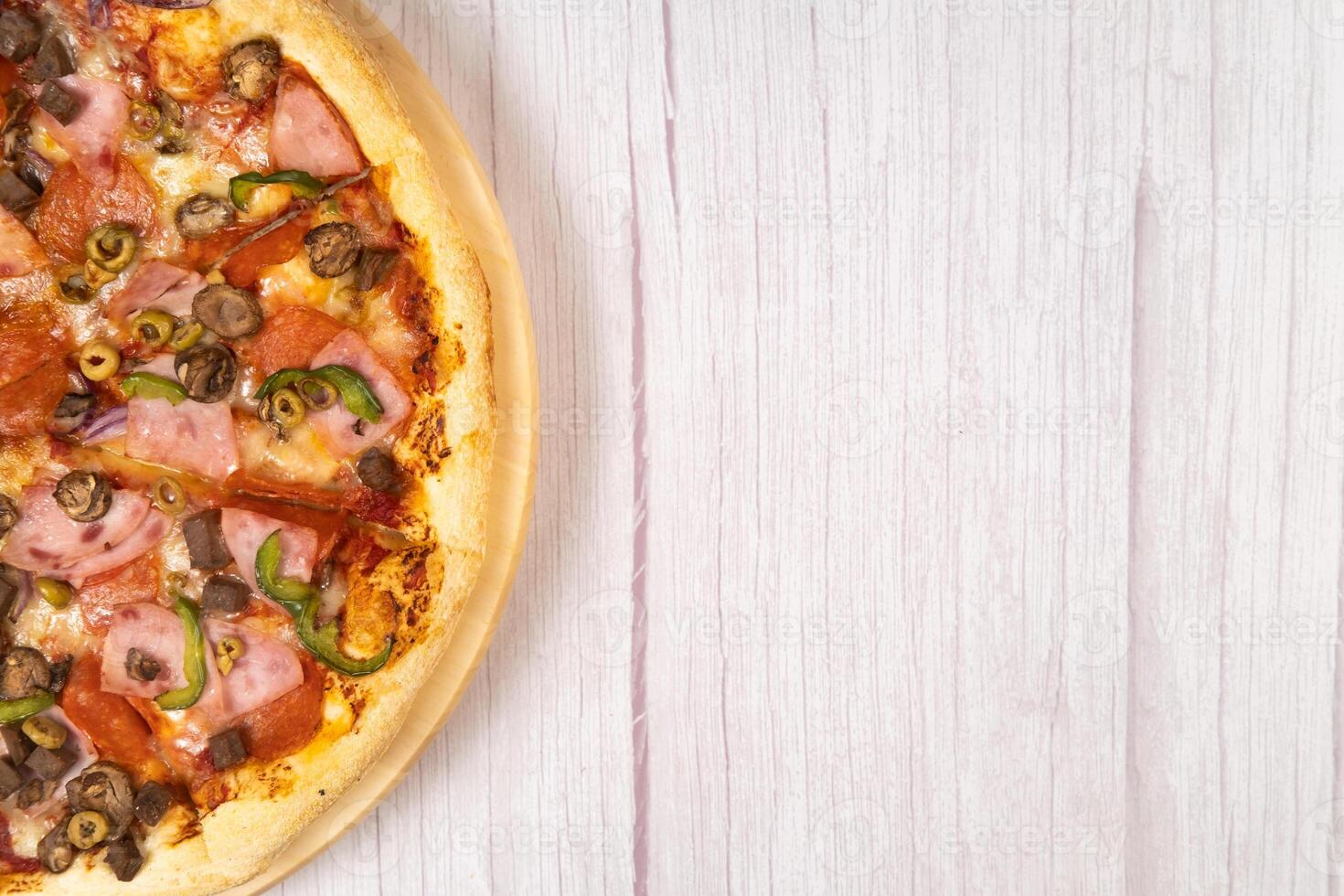 Delicious large pizza with veal and mushrooms on a light wooden background photo