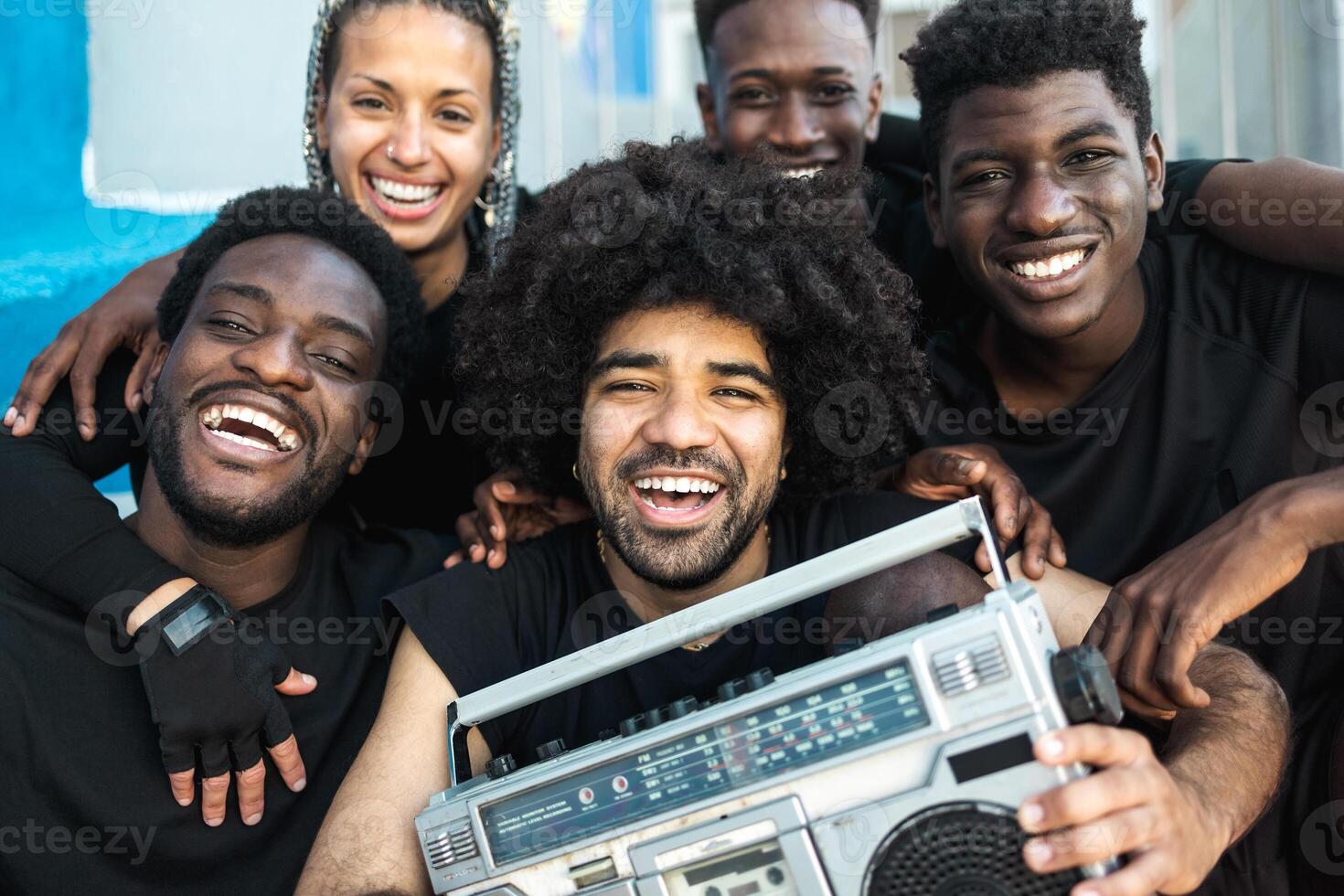 Happy group of multiracial people having fun listening music with vintage boombox outdoor - Youth people lifestyle photo