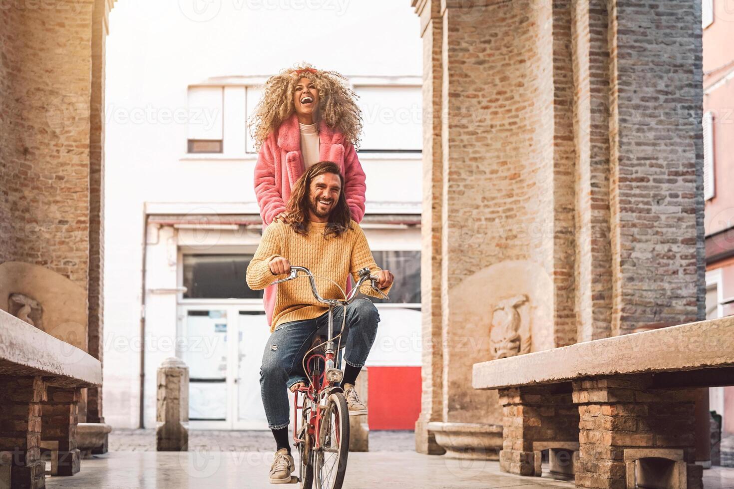 contento Pareja yendo en bicicleta en el ciudad centrar - joven personas teniendo divertido al aire libre - milenario Generacion y juventud estilo de vida concepto foto