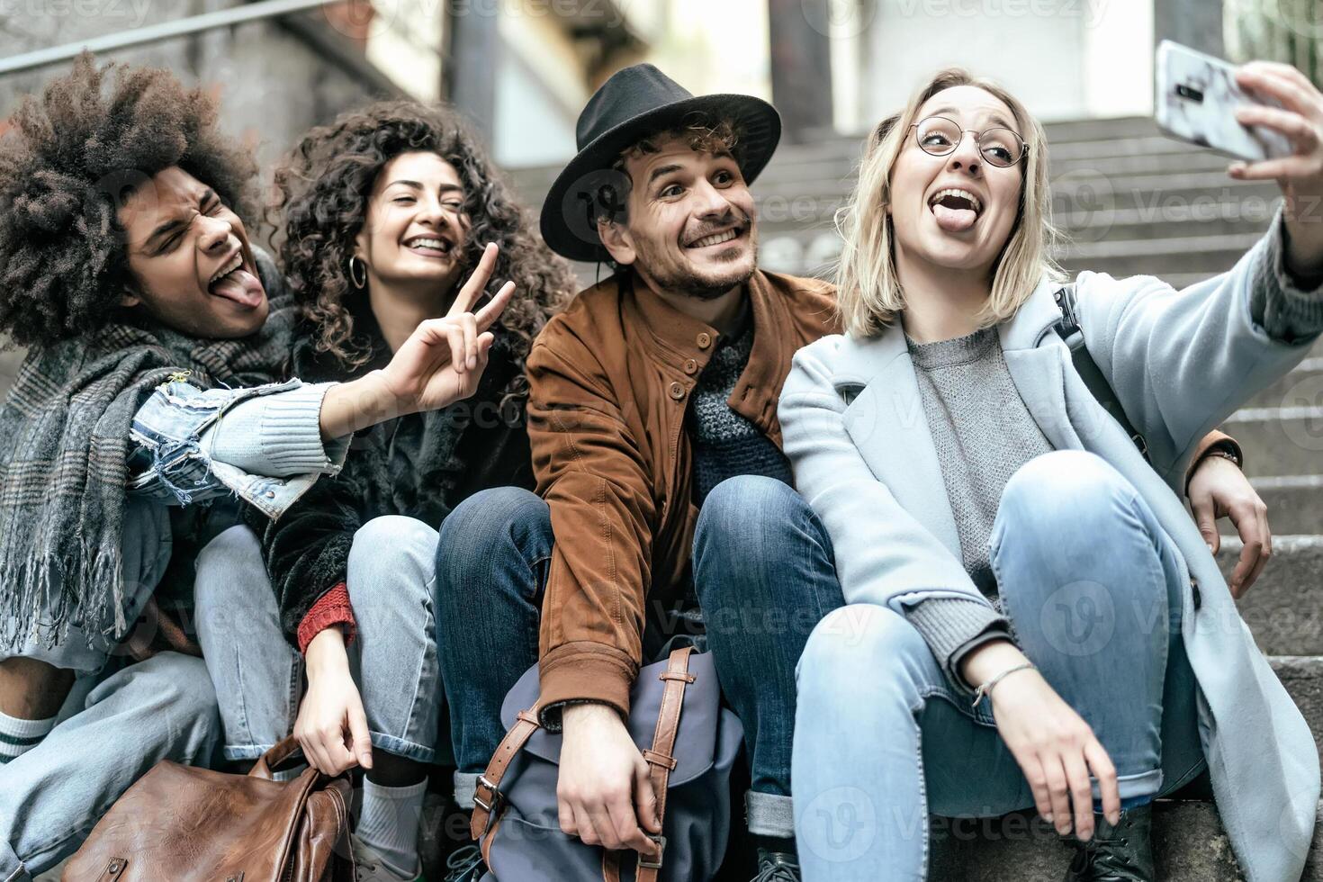 joven multirracial grupo de amigos tomando selfie con móvil teléfono inteligente sentado en urbano escalera - juventud milenario estilo de vida concepto foto