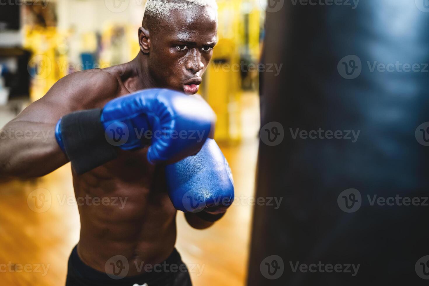 Man boxer training hard - Young black guy boxing in sport gym center club - Health fitness and sporty activity concept photo