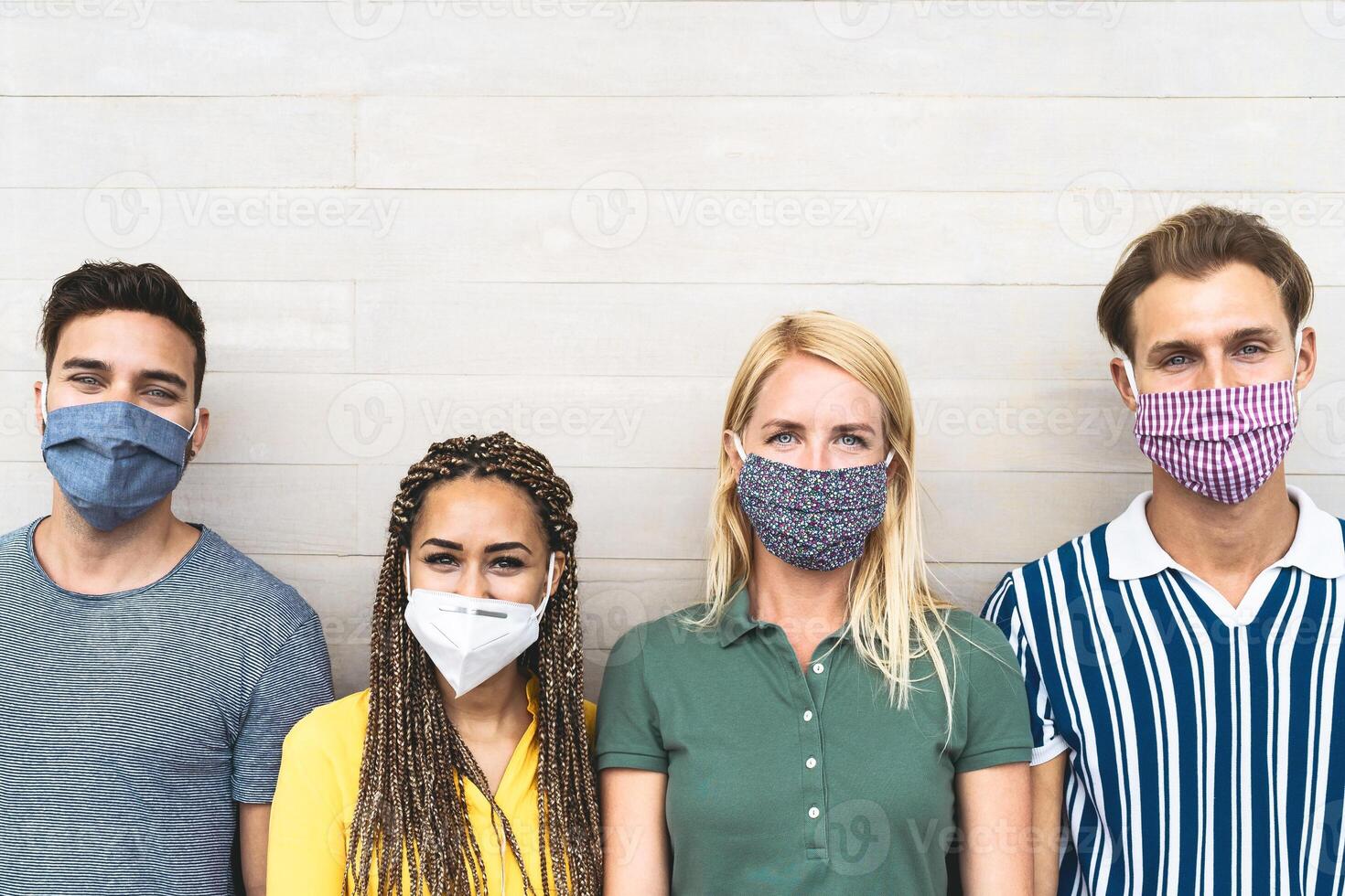 Multiracial friends wearing face mask for preventing and stop corona virus spread - Youth millennial generation lifestyle during covid-19 crisis photo
