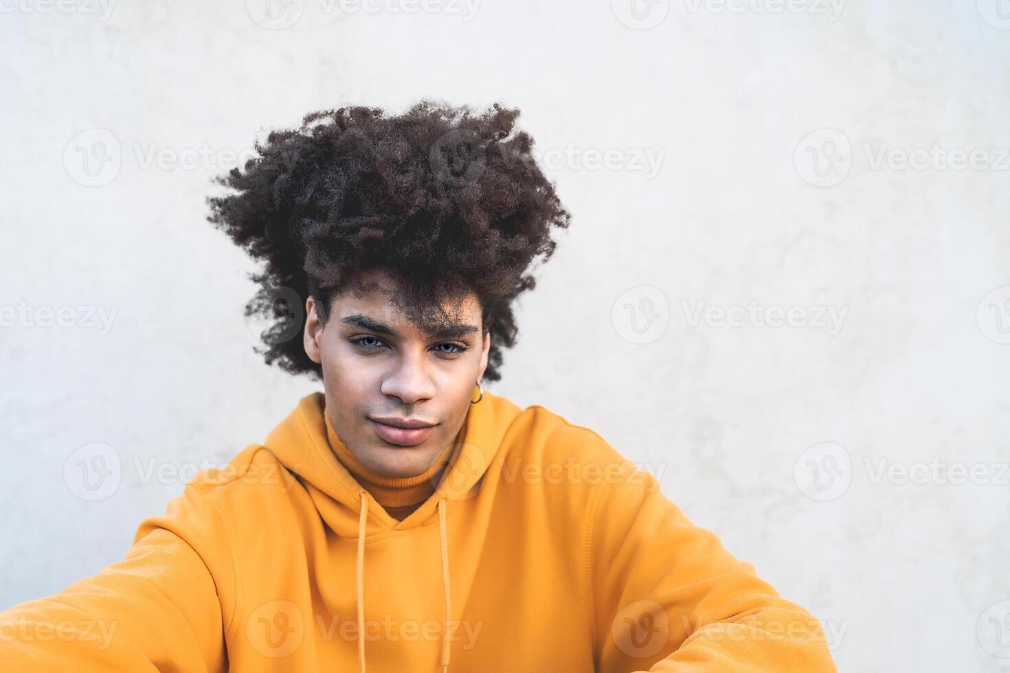 Afro smiling man portrait - Mixed race young guy with curly hair posing in front camera - Youth millennial generation culture and multiracial people concept photo