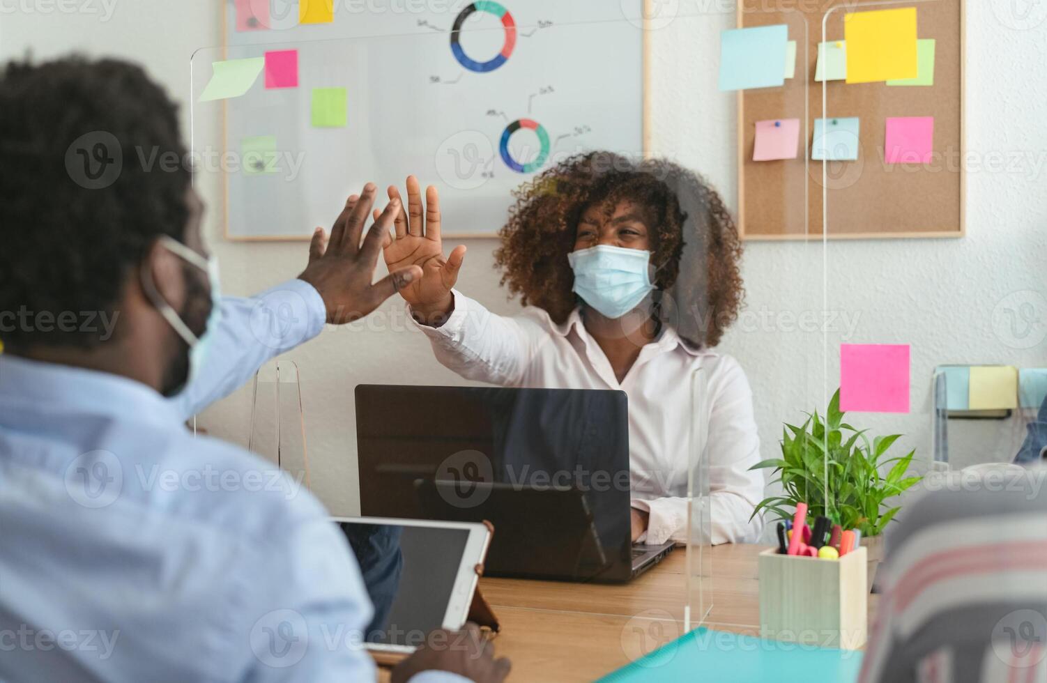 Young African people in co-working creative space wearing surgical mask protection and keeping social distance to avoid corona virus spread - Health care and business technology concept photo