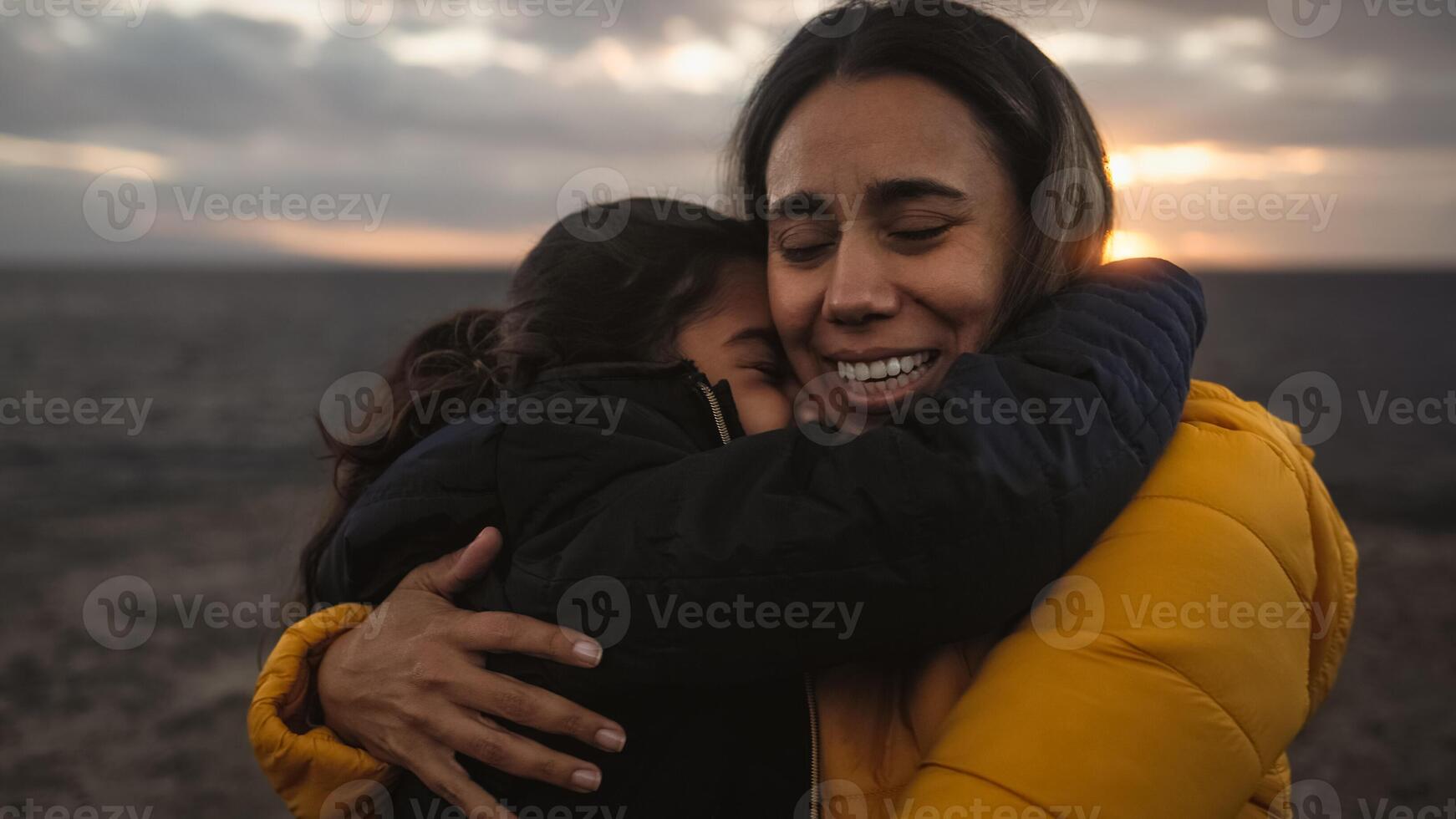 Happy Latin mother enjoying time with her child on the beach - Family and love concept photo