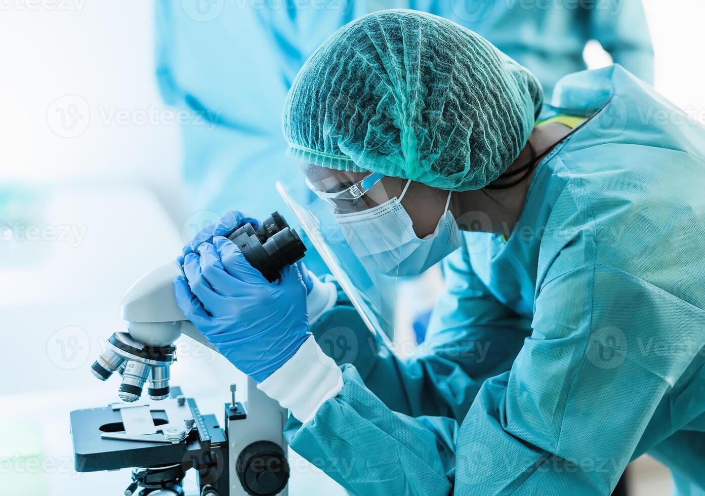 hembra científico examinando mediante microscopio en hospital laboratorio - Ciencias y tecnología concepto foto