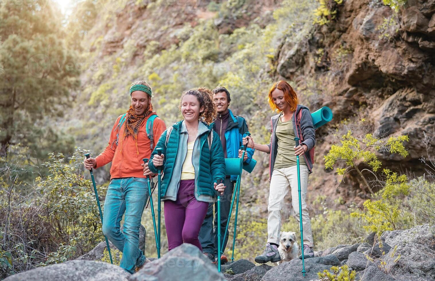 Group of friends with backpacks doing trekking excursion on mountain - Young  tourists walking and exploring the wild nature - Trekker, sport, hike and travel concept photo