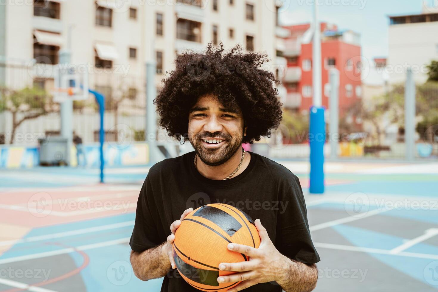contento hombre jugando baloncesto al aire libre - urbano deporte estilo de vida concepto foto