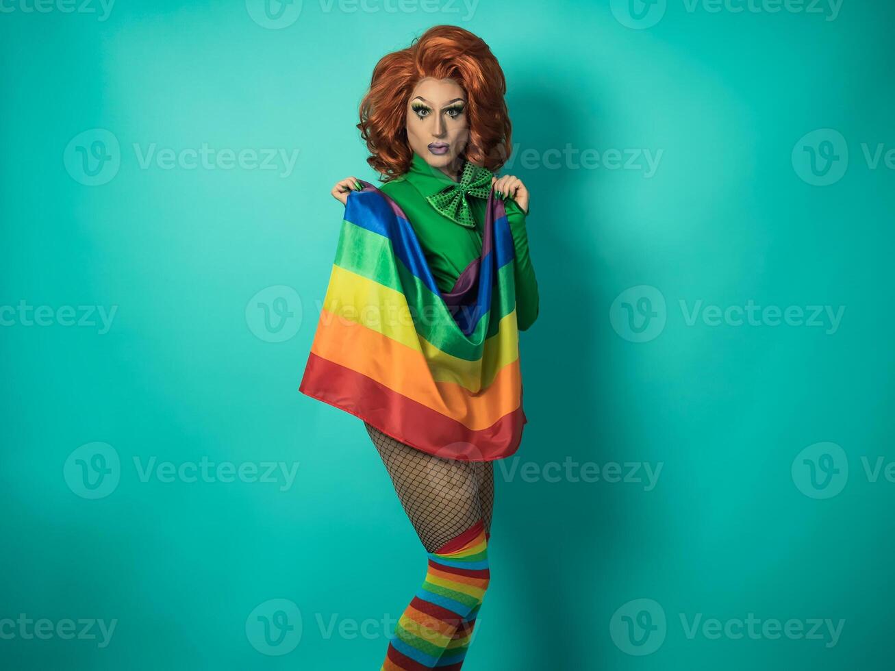 Happy drag queen celebrating gay pride holding rainbow flag - LGBTQ social community concept photo