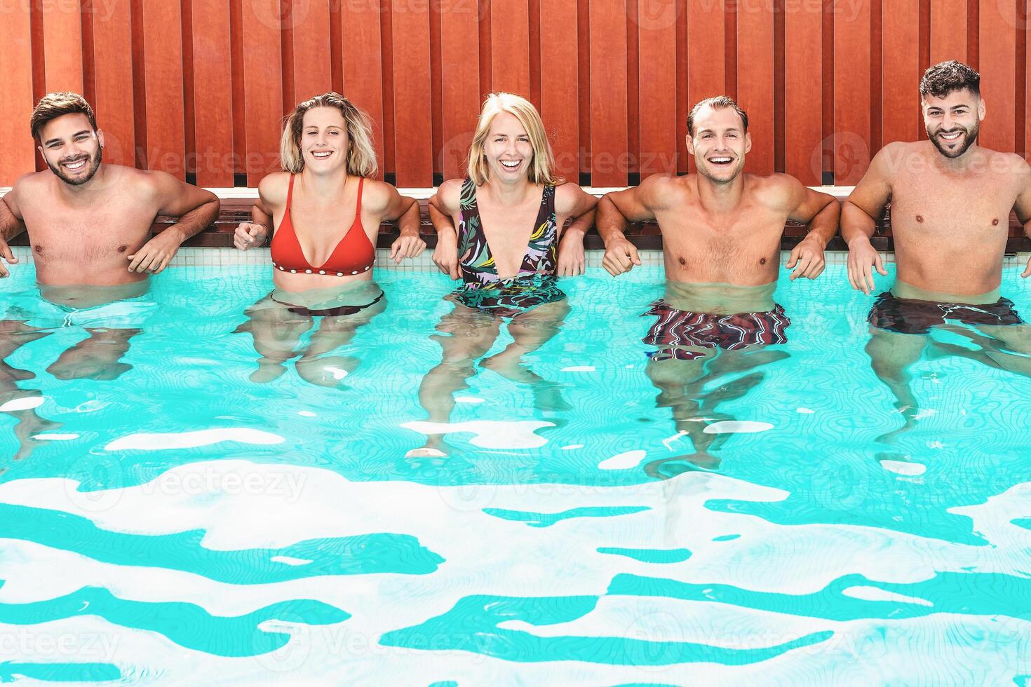 Happy friends enjoying summer day in swimming pool - Young people having fun in exclusive private villa - Youth vacation lifestyle concept photo