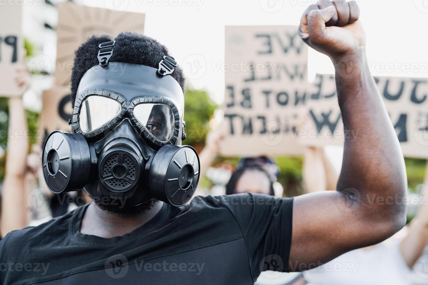 Activist wearing gas mask protesting against racism and fighting for equality - Black lives matter demonstration on street for justice and equal rights - Blm international movement concept photo