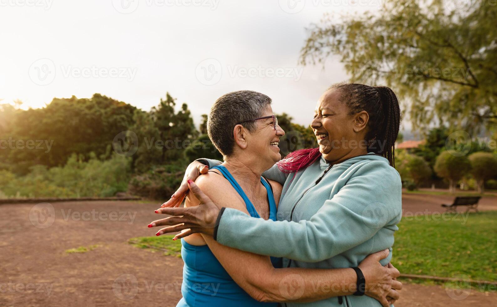 Happy multiracial senior women having fun after workout activities in a public park - Healthy elder people concept photo
