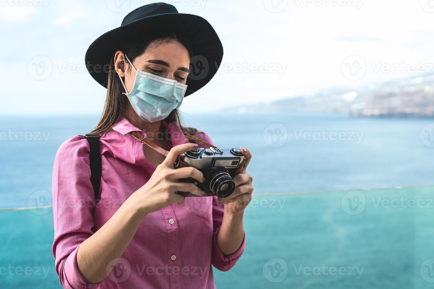 joven viaje mujer fotografiando con antiguo Clásico cámara - contento niña vistiendo cara quirúrgico máscara explorador nuevo turístico destinos - salud cuidado y turismo concepto foto