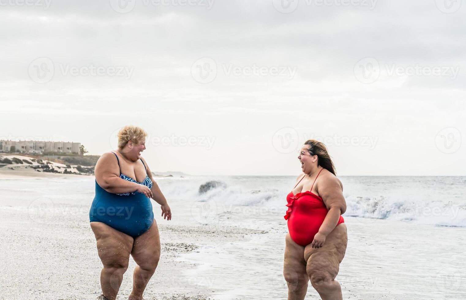 Happy plus size women having fun on the beach during summer vacation - Curvy confident people lifestyle concept photo