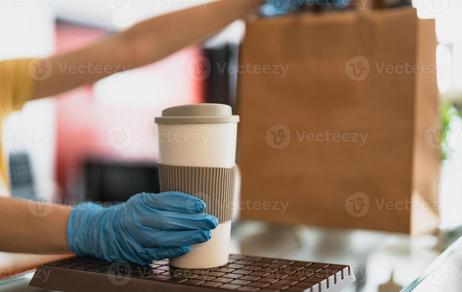 Bar owner working only with take away orders during corona virus outbreak - Young woman worker wearing surgical gloves giving takeout meal and coffee to customers - Healthcare and Food drink concept photo