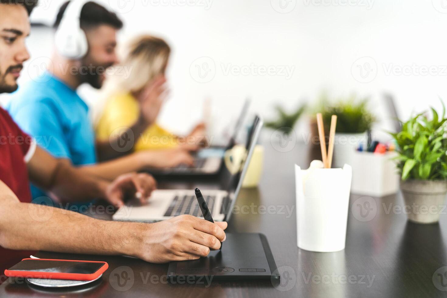Young friends working together inside co-working creative space - Millennial people doing startup strategy in modern office - Youth generation and technology concept photo