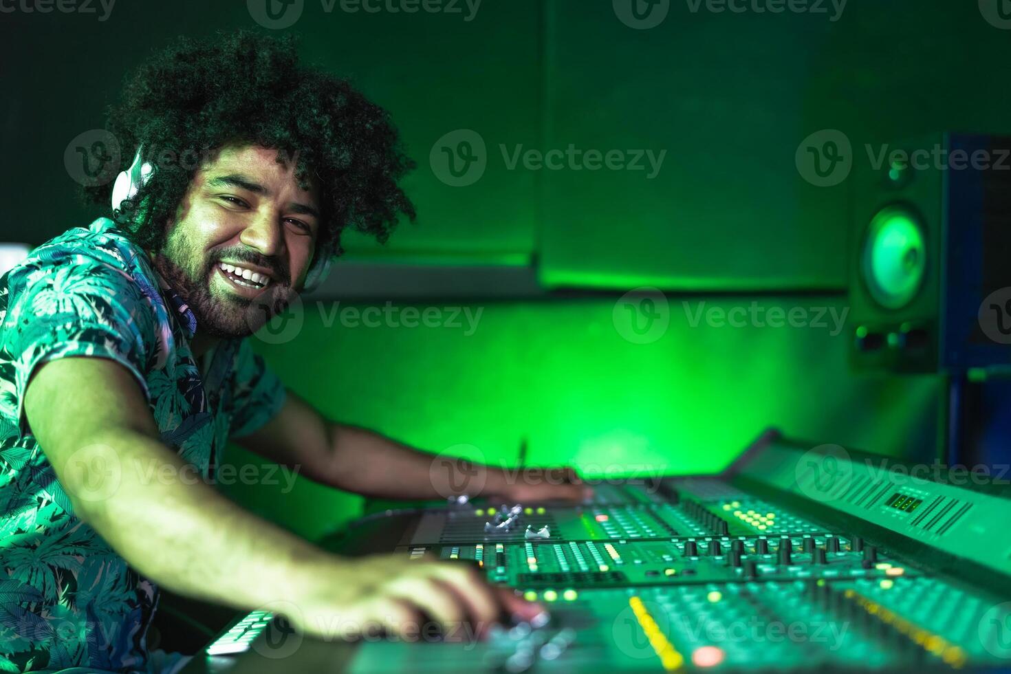 Young Afro man working in music recording studio - Male audio engineer mixing a sound in production house photo