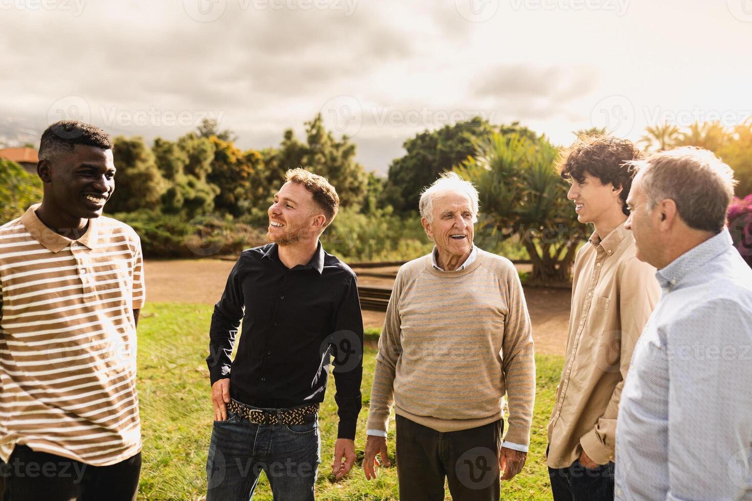 Happy multigenerational group of men with different ethnicities having fun in a public park - People diversity concept photo