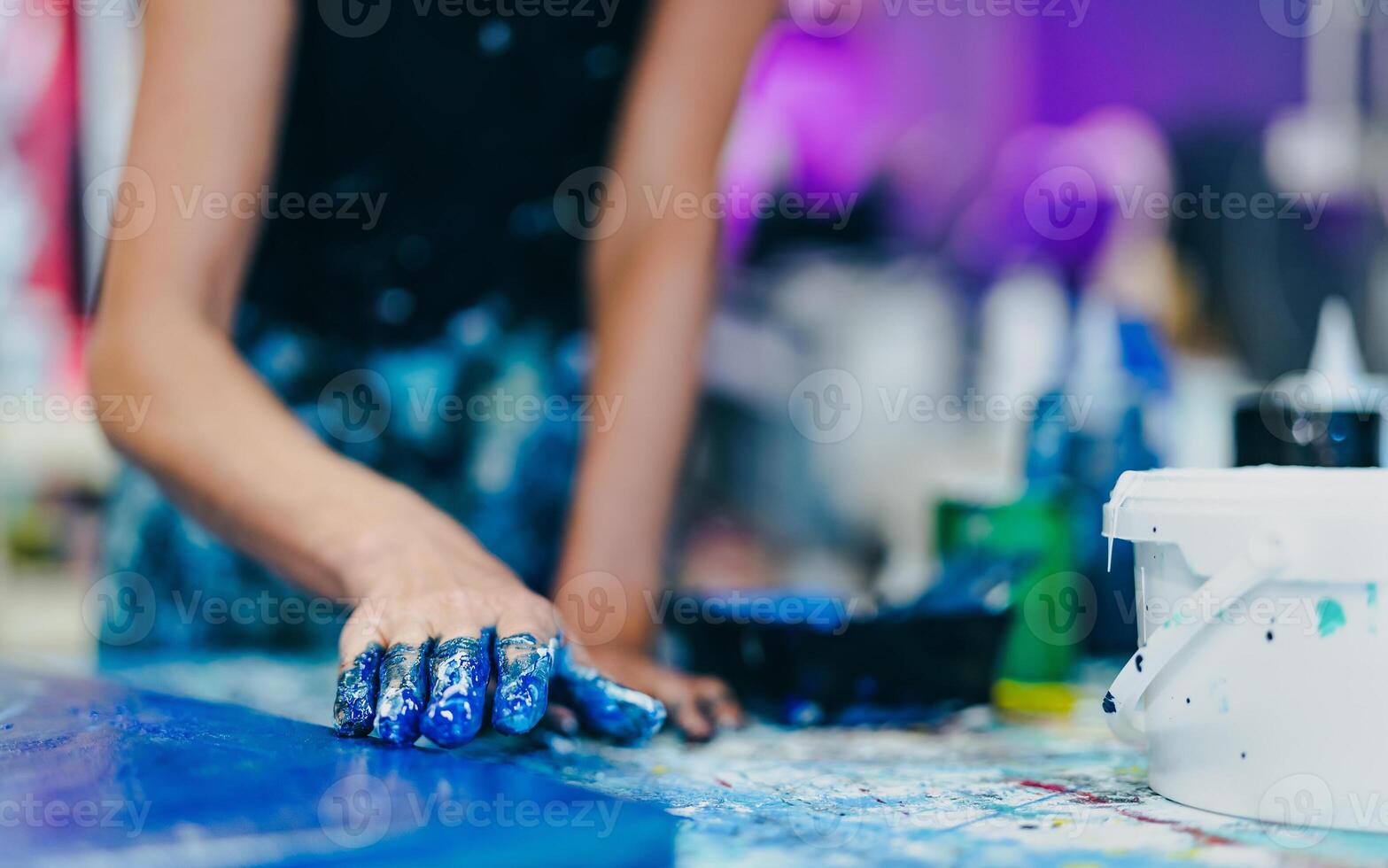 Woman artist painting with hands on canvas in workshop studio - Painter work and creative craft concept photo