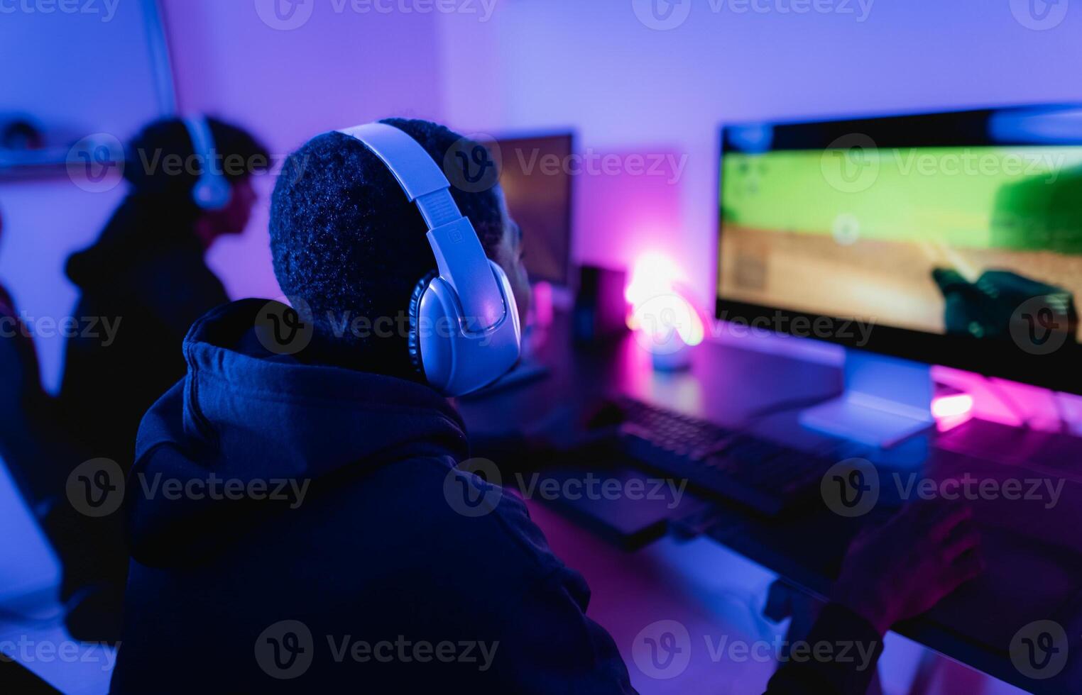 Young gamers having fun playing online video games with computer at home - Gaming entertainment and technology concept photo