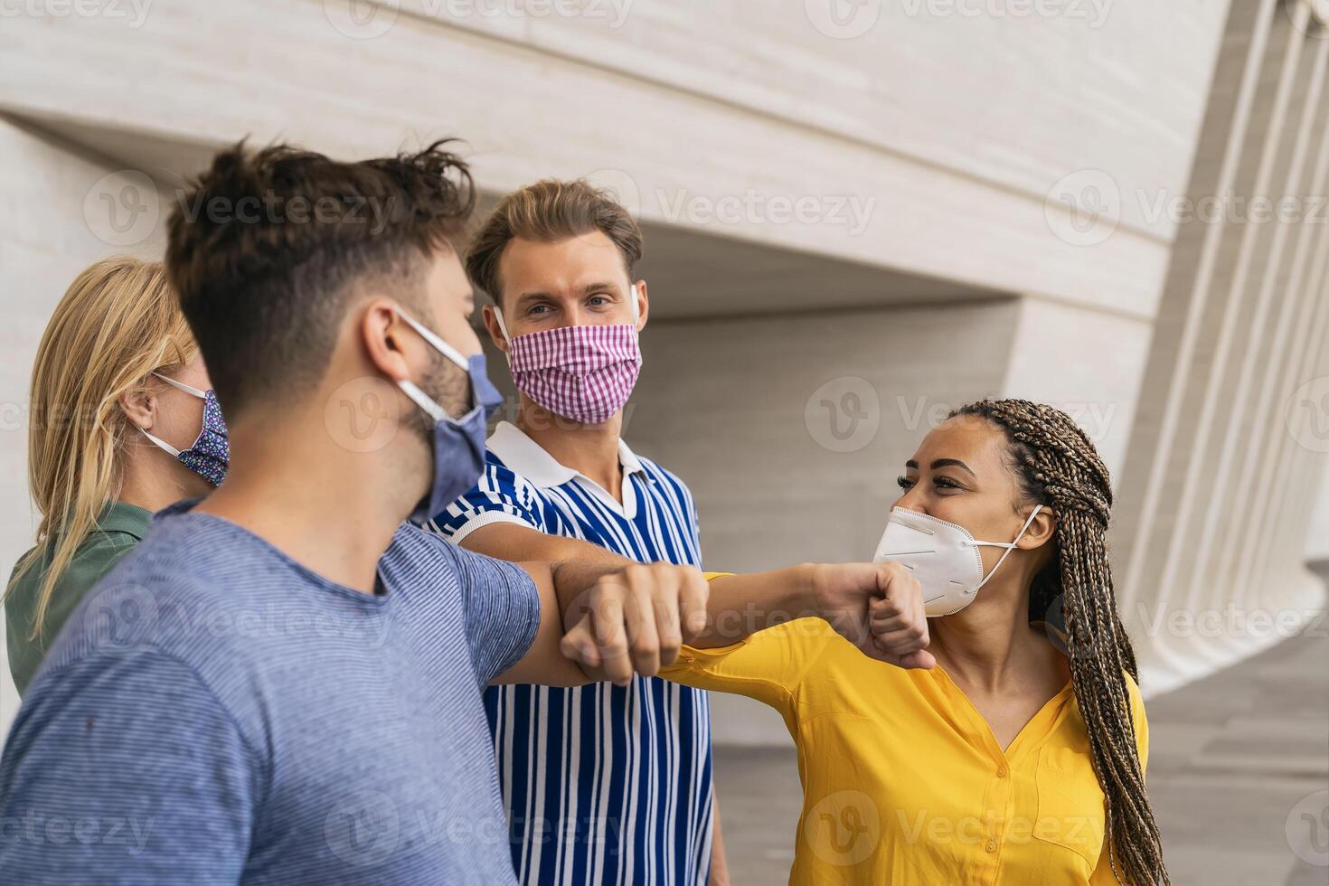 joven amigos vistiendo cara protector máscara haciendo nuevo social distanciamiento saludar con codos golpes para prevenir corona virus untado - físico distancia y amistad la seguridad saludos concepto foto