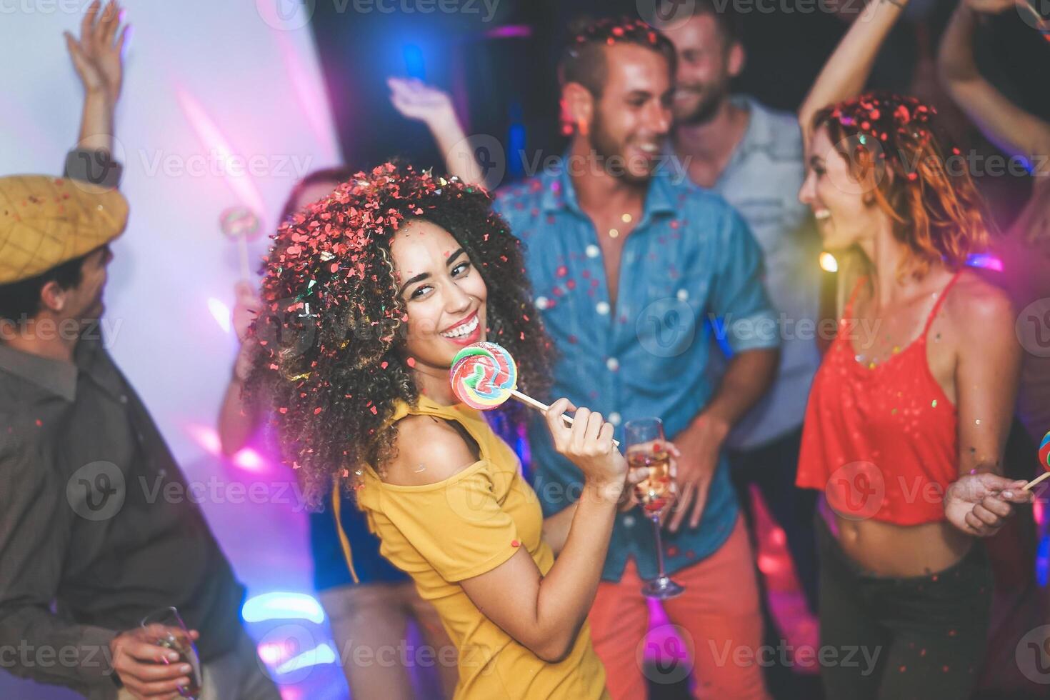 grupo de amigos bailando y Bebiendo champán a Club nocturno - joven contento personas teniendo divertido y disfrutando fiesta comiendo caramelo piruletas - juventud amistad estilo de vida concepto foto