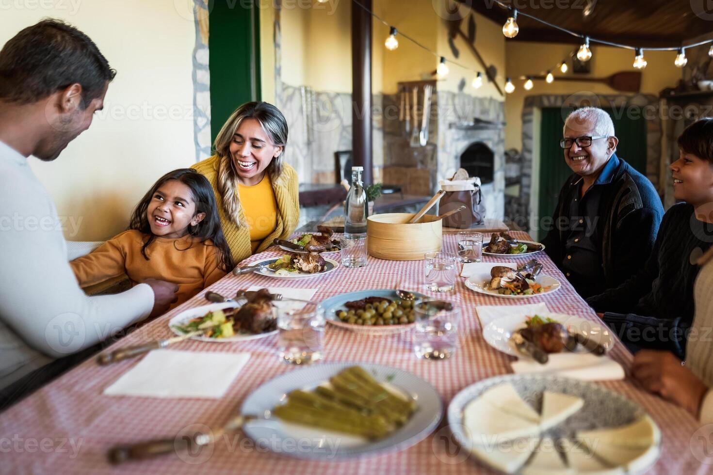Happy Latin family having fun dining together at home photo