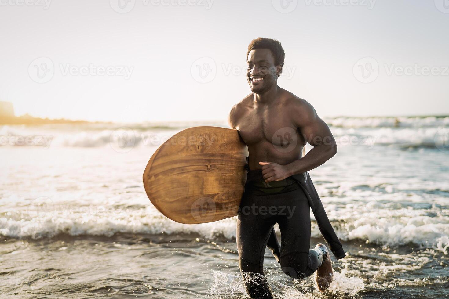 Male afro surfer having fun surfing during sunset time - African man enjoying surf day - Extreme sport lifestyle people concept photo