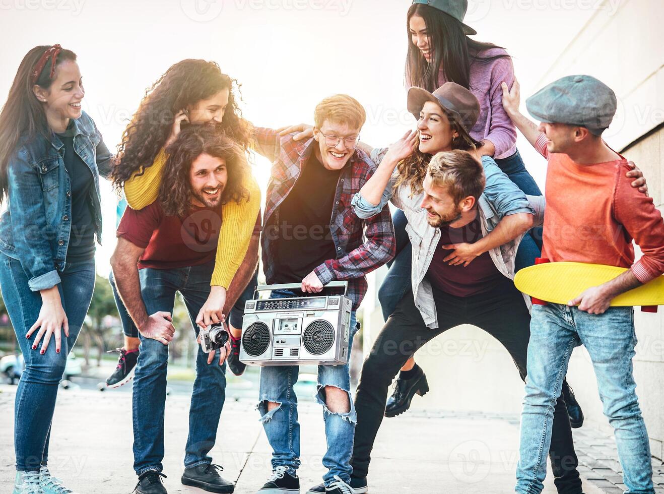 Group of young people having fun in the city center - Happy friends piggybacking while laughing and walking together outdoor - Friendship, millennial generation, teenager and youth lifestyle concept photo