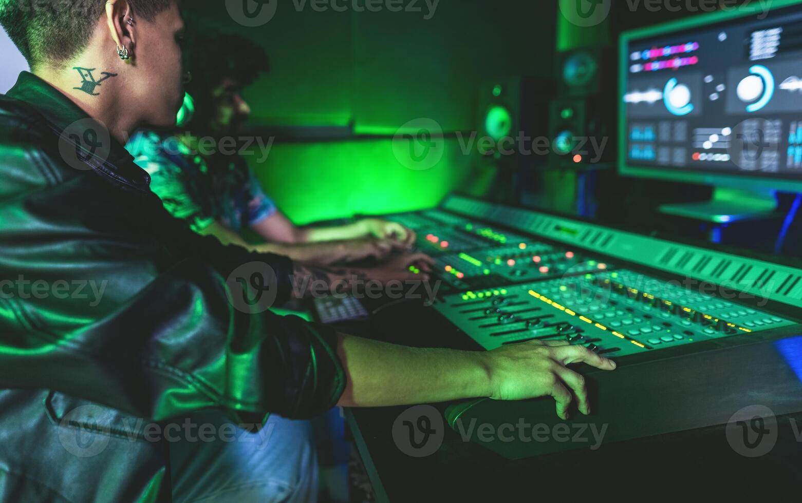 Young audio engineer people having fun working with mixer sound panel in music recording studio photo