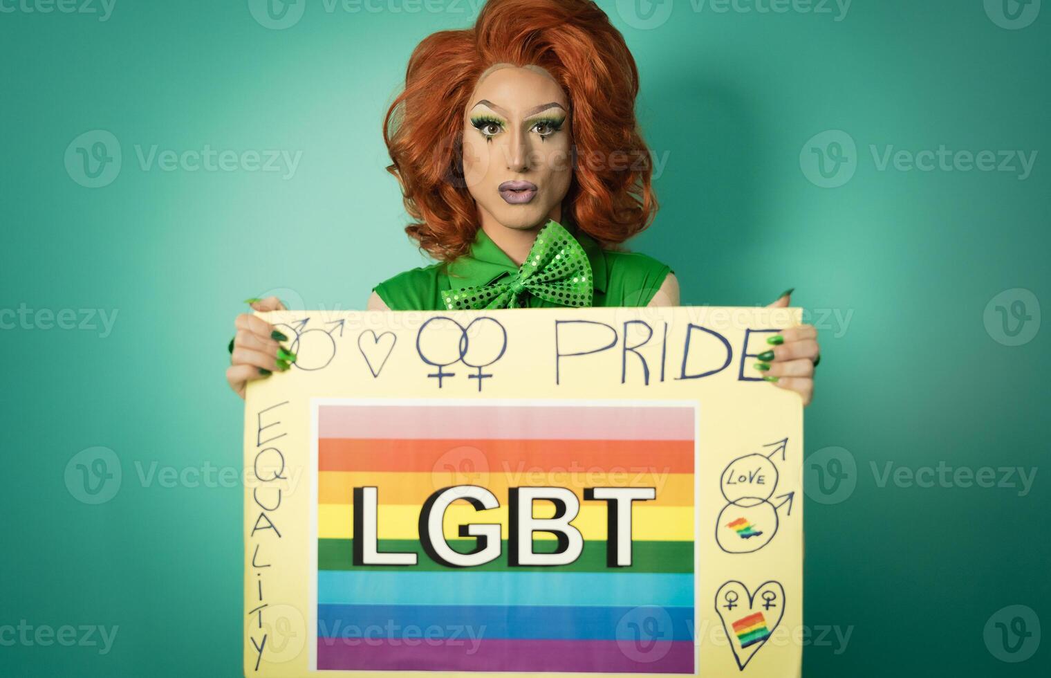 Drag queen celebrating gay pride holding banner with rainbow flag - LGBTQ social community concept photo