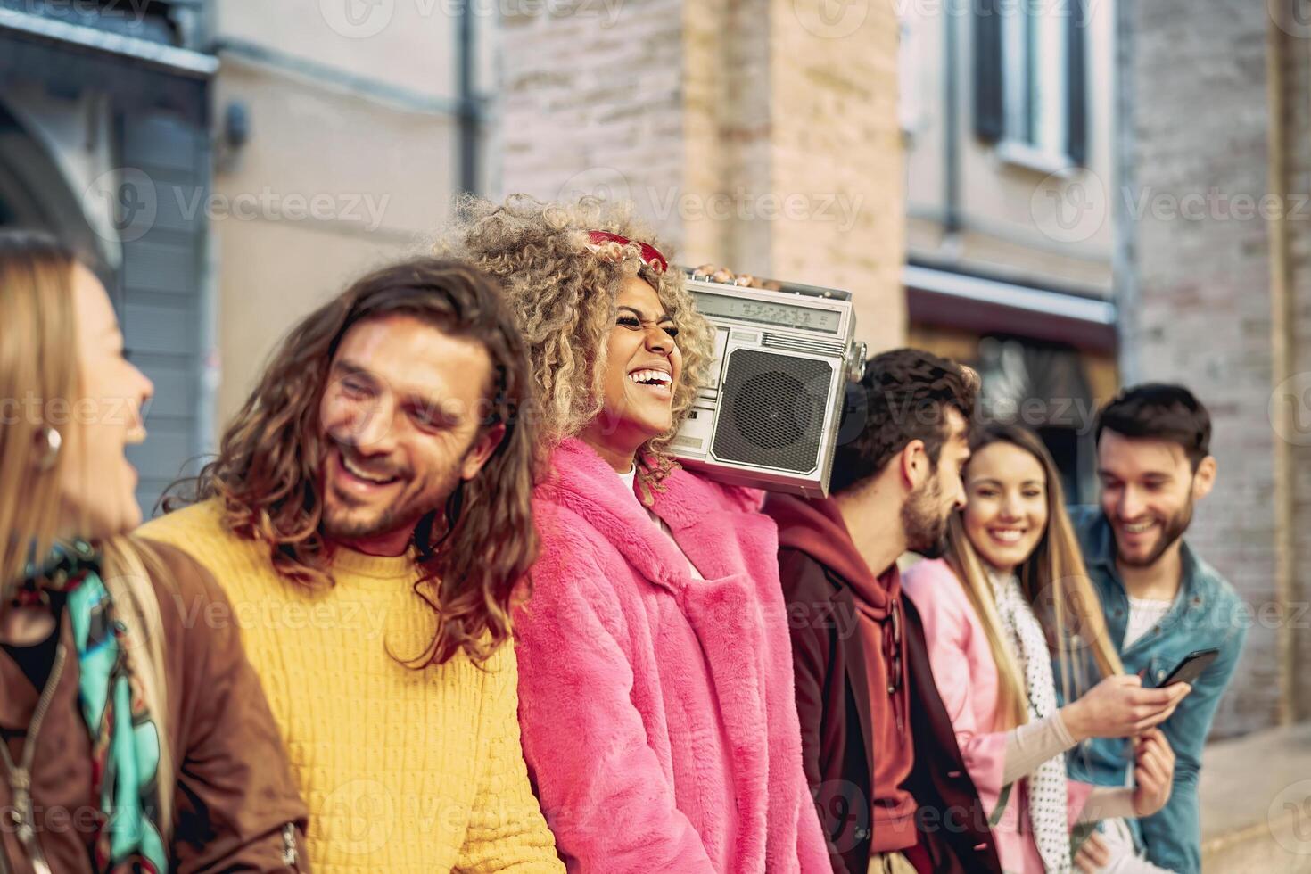 grupo de amigos teniendo divertido escuchando música con Clásico boombox - contento joven personas haciendo fiesta al aire libre - juventud cultura y milenario estilo de vida concepto foto