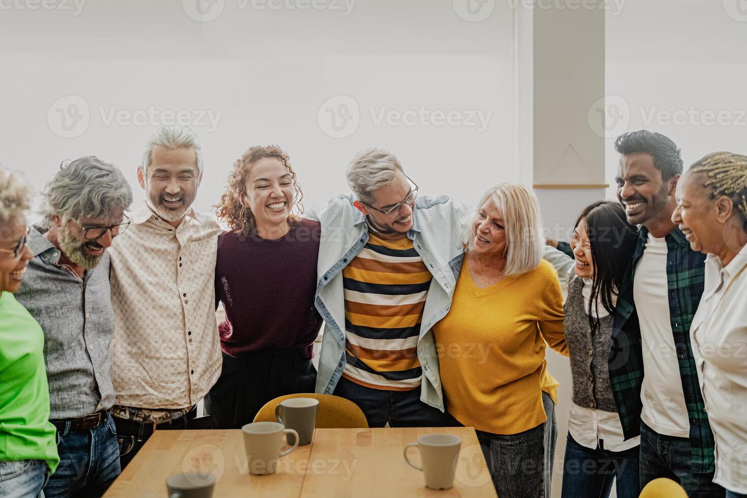 Happy multiracial people with different ages and ethnicities having fun drinking a cup of coffee at home photo