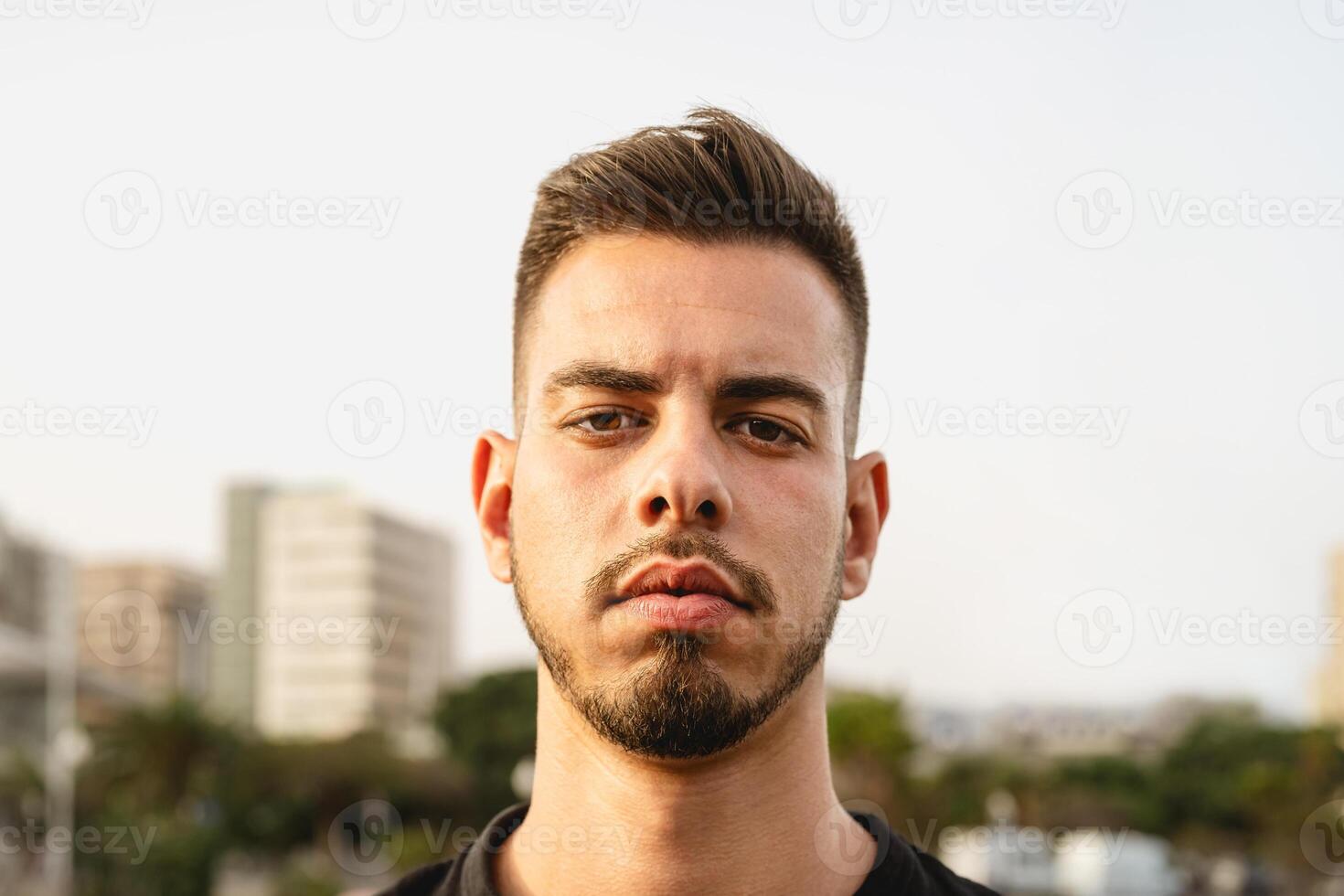 joven hombre mirando en frente de cámara en el ciudad foto
