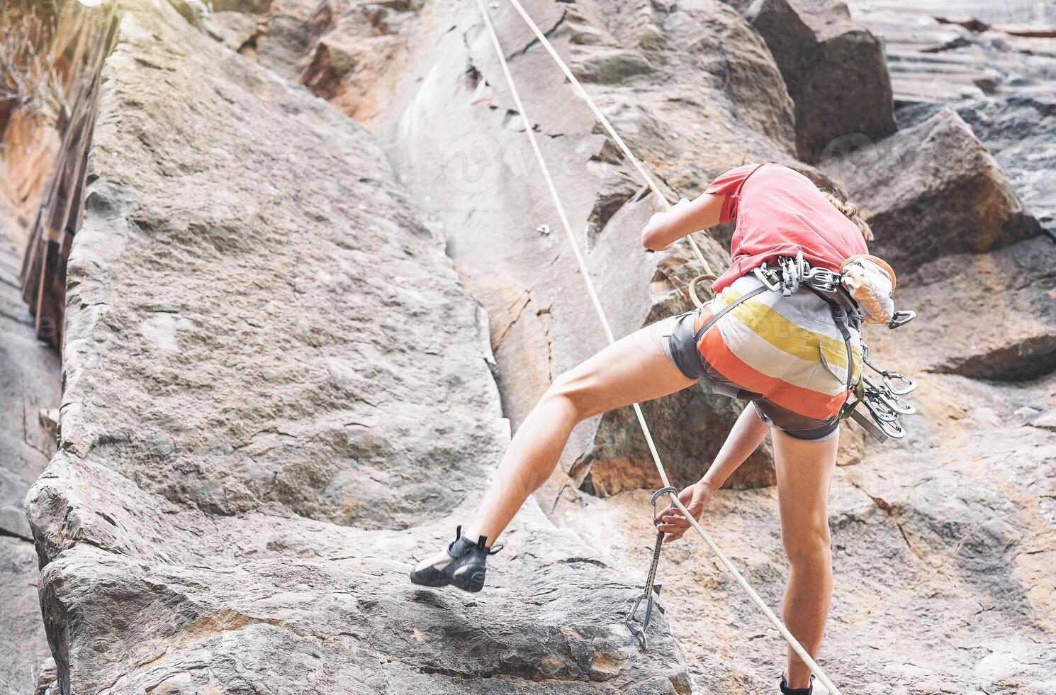 Athletic strong man clambing a rock wall - Climber performing on a canyon mountain - Concept of extreme sport, lifestyle travel and adrenaline photo