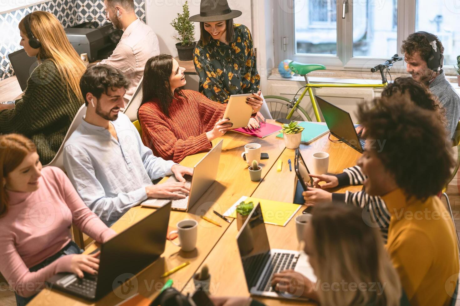 Happy young people working together inside office - Multiracial friends having fun in coworking space - Youth co-workers millennial generation and technology workspace concept photo