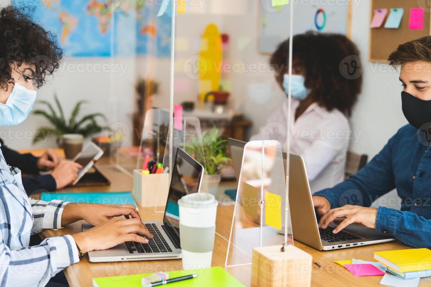 Young people in co-working creative space wearing surgical mask and keeping social distance to avoid corona virus spread - Health care and business technology concept photo