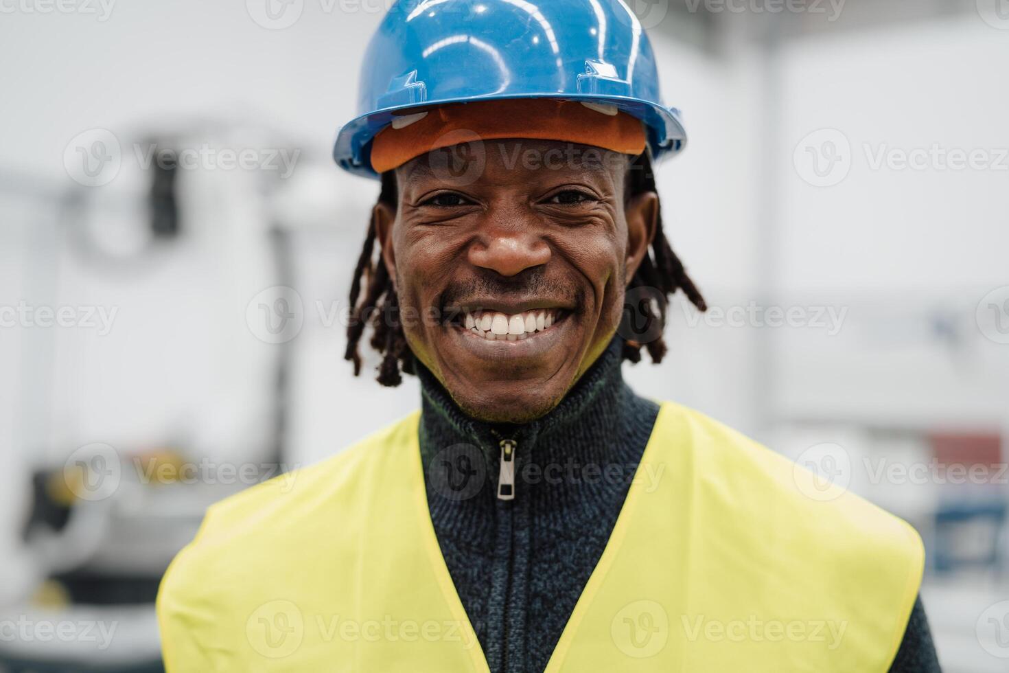 Happy African engineer man working inside automation factory - Industrial concept photo